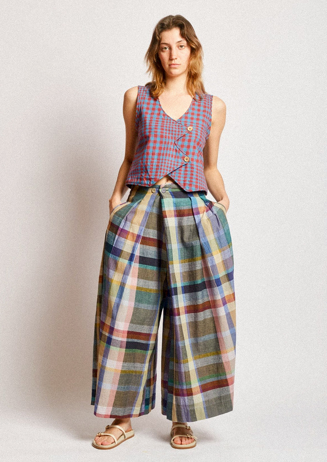 A woman wearing a pair of colorful multicolor check print wide leg pants.