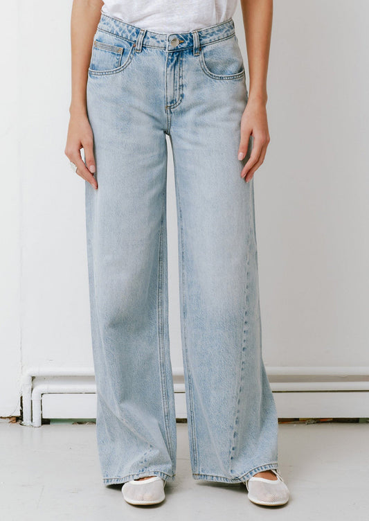 A woman wearing a pair of slouchy wide leg jeans in a light blue denim.