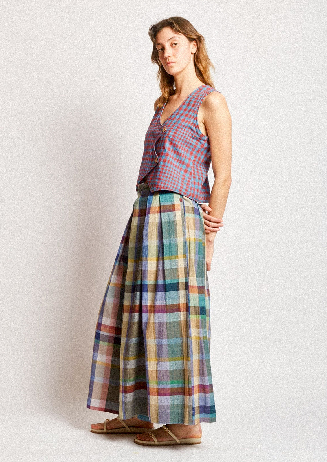 A woman wearing a pair of colorful multicolor check print wide leg pants.