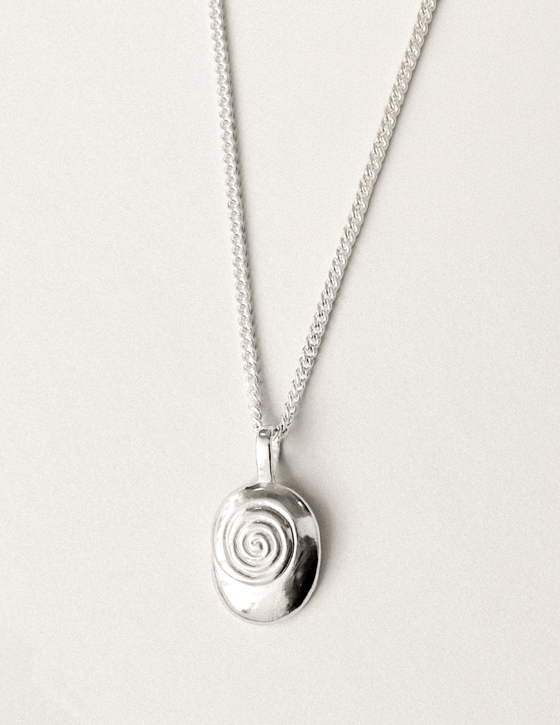 A sterling silver necklace with nautilus shaped pendant.