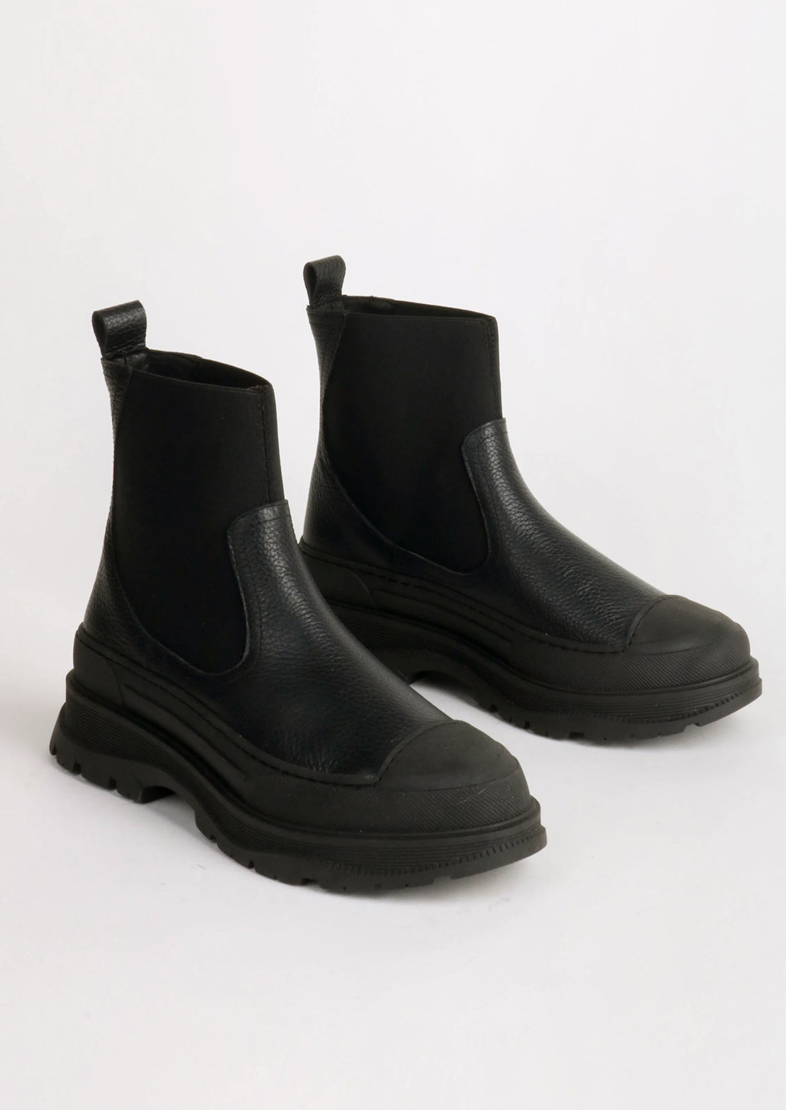 A pair of black boots with elastic ankle, rubber cap toe and chunky lug sole.