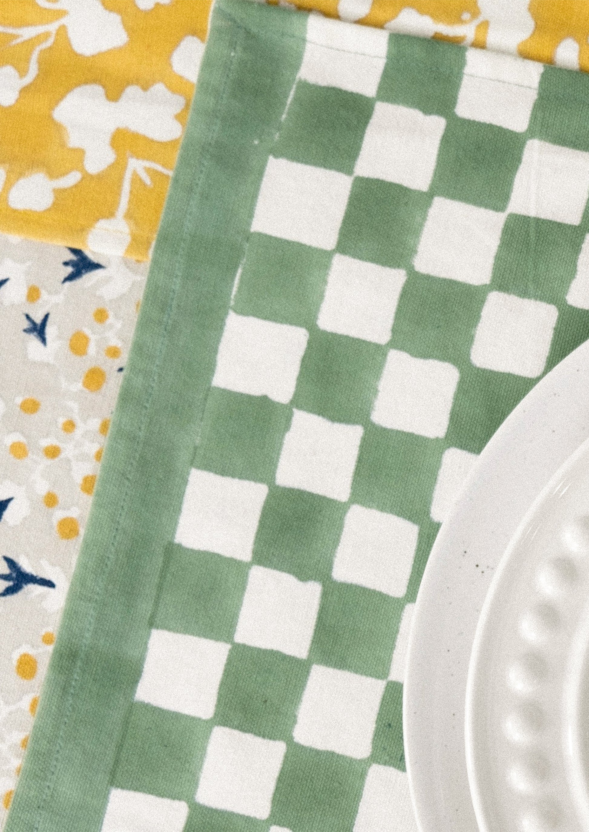 A block printed placemat with checkered pattern in clover green.