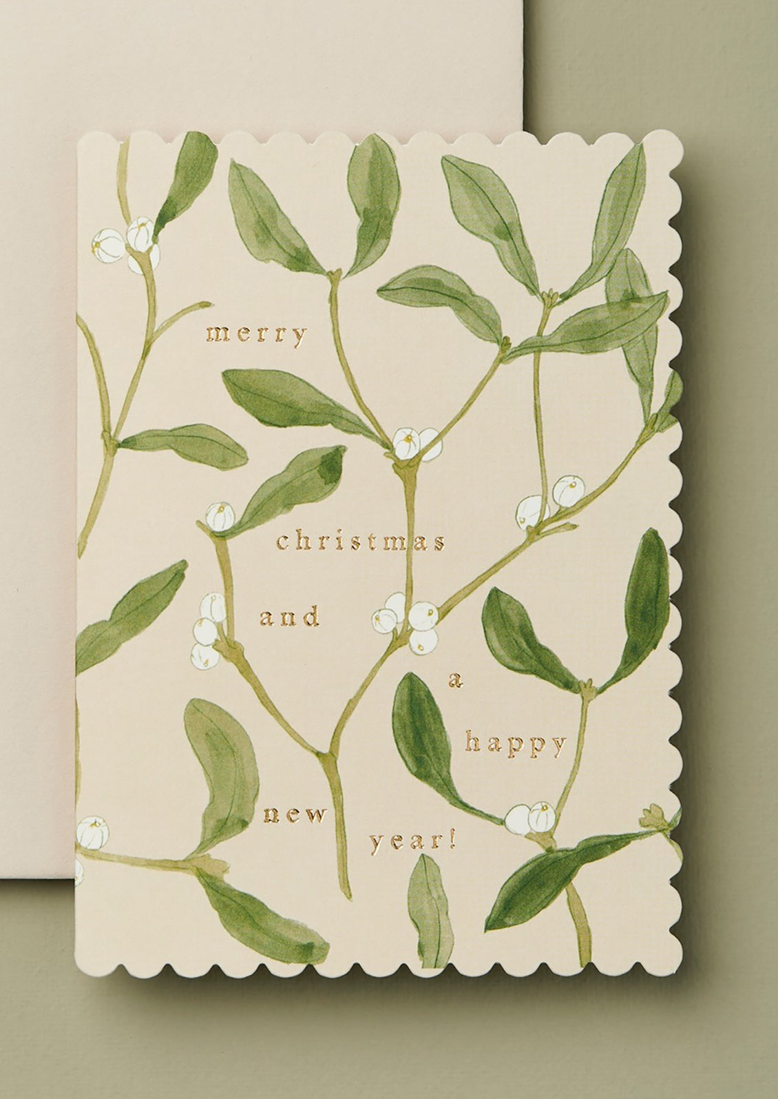 Christmas card with mistletoe design and text on a beige background