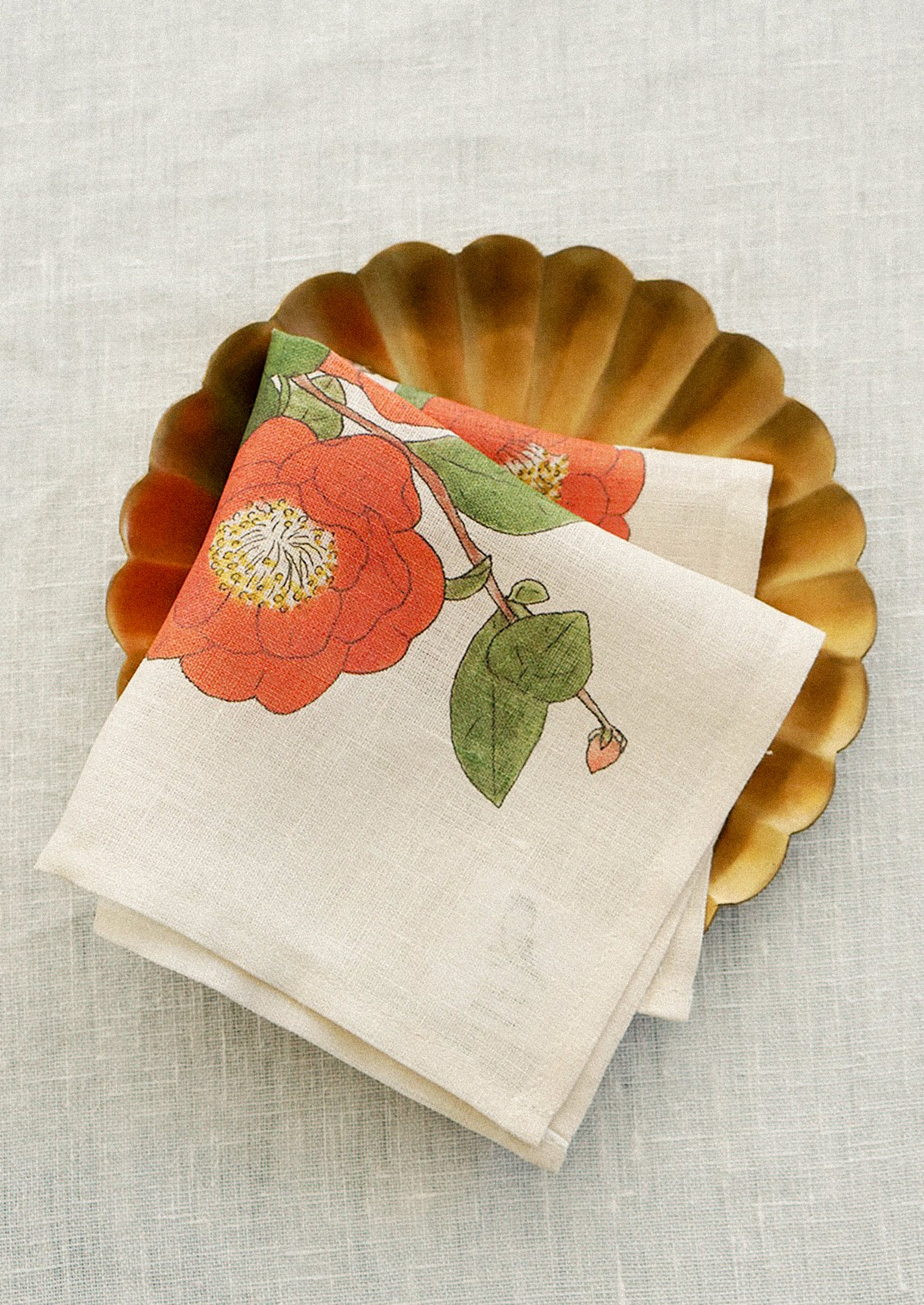 A linen handkerchief with screen printed red camellia illustration.