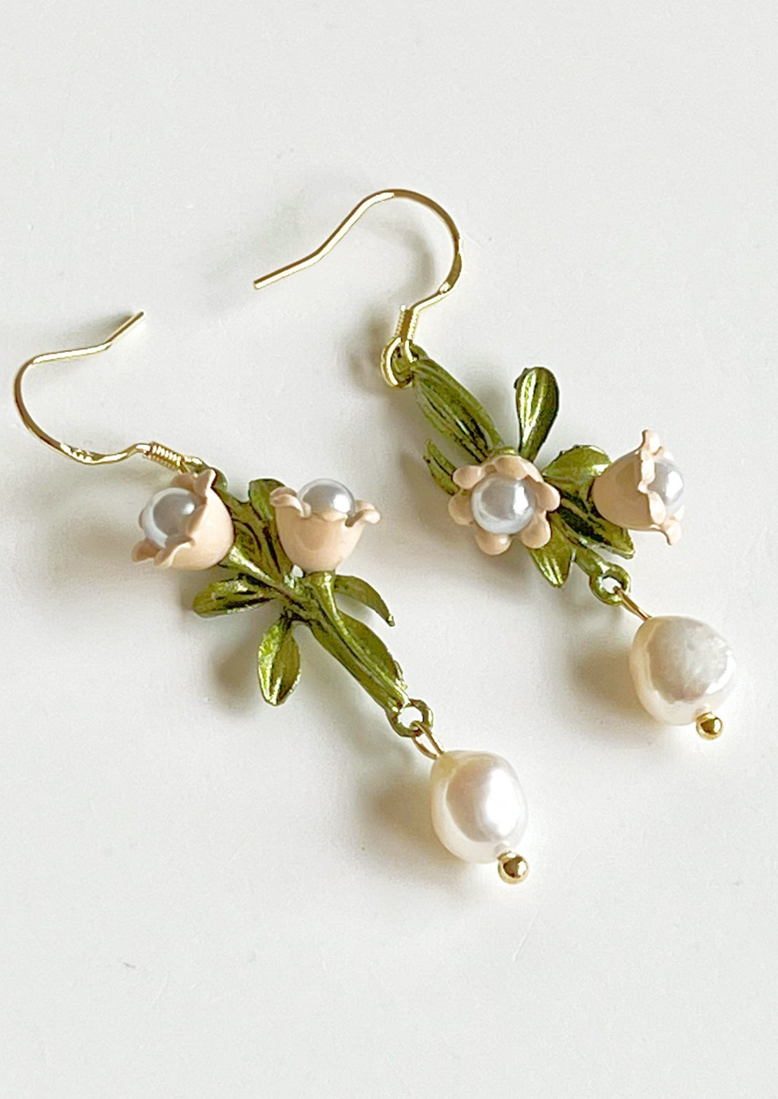 A pair of beaded drop earrings with leaf and pearl flower beading.
