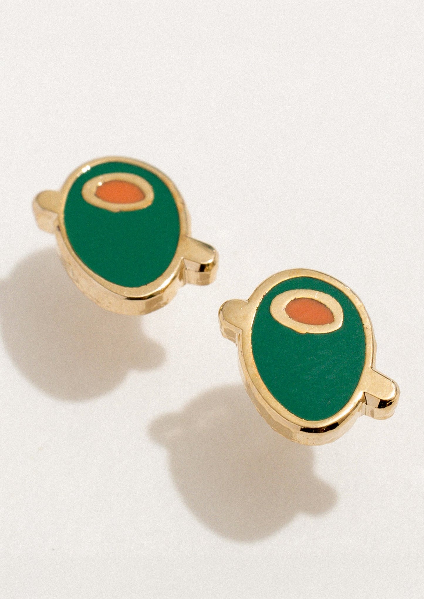 A pair of small enamel stud earrings depicting an olive.