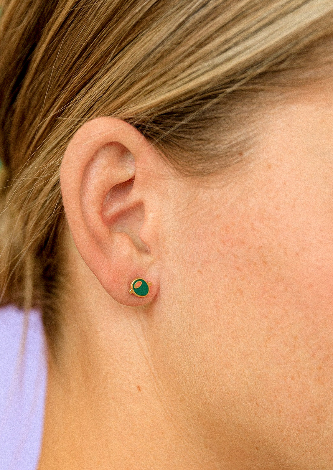 A pair of small enamel stud earrings depicting an olive.