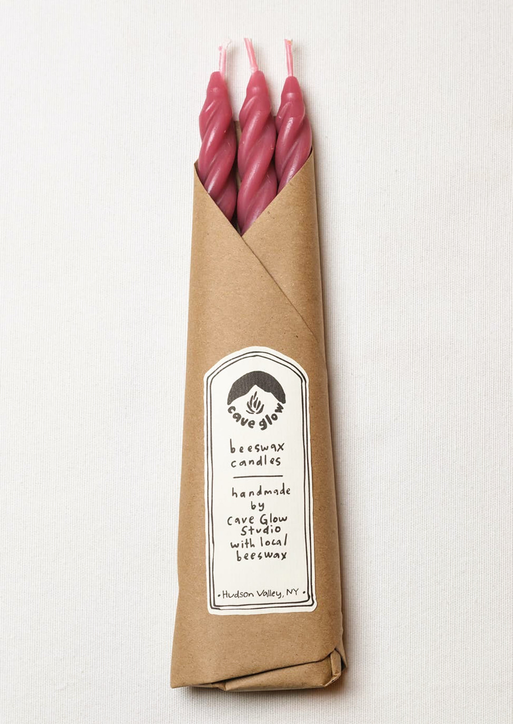 A set of three spiral textured taper candles in berry color.