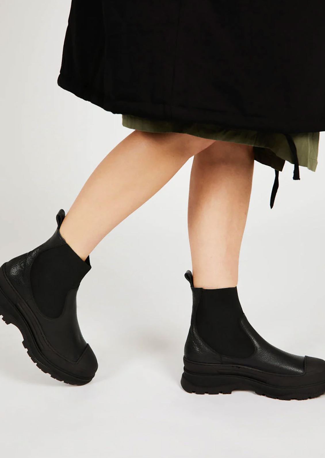 A pair of black boots with elastic ankle, rubber cap toe and chunky lug sole.