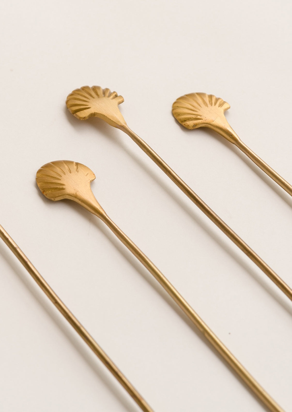 Seashell drink stirrers in solid bras.