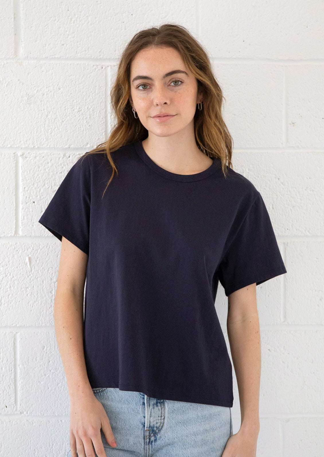 A woman wearing a short sleeve cotton t-shirt in navy blue.