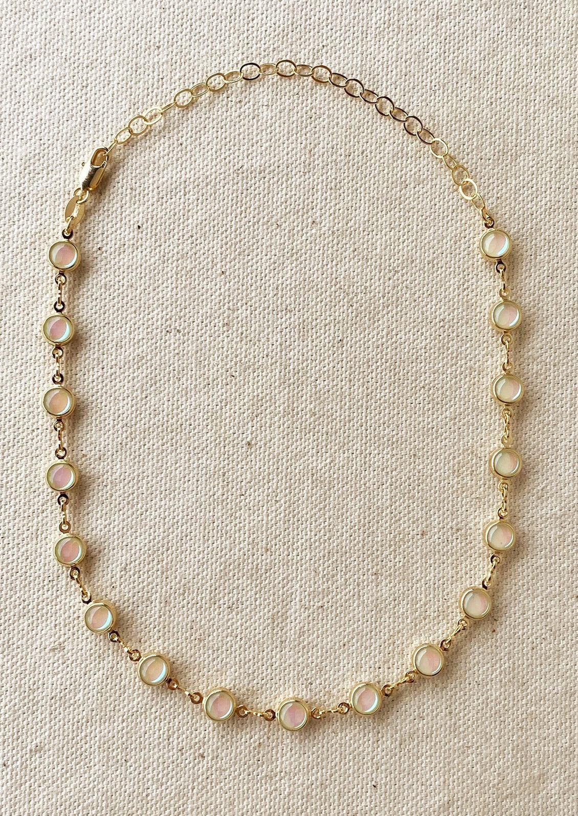 A gold necklace with round opal stations throughout.