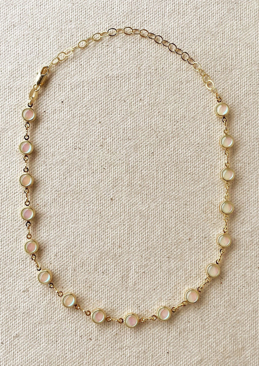 A gold necklace with round opal stations throughout.