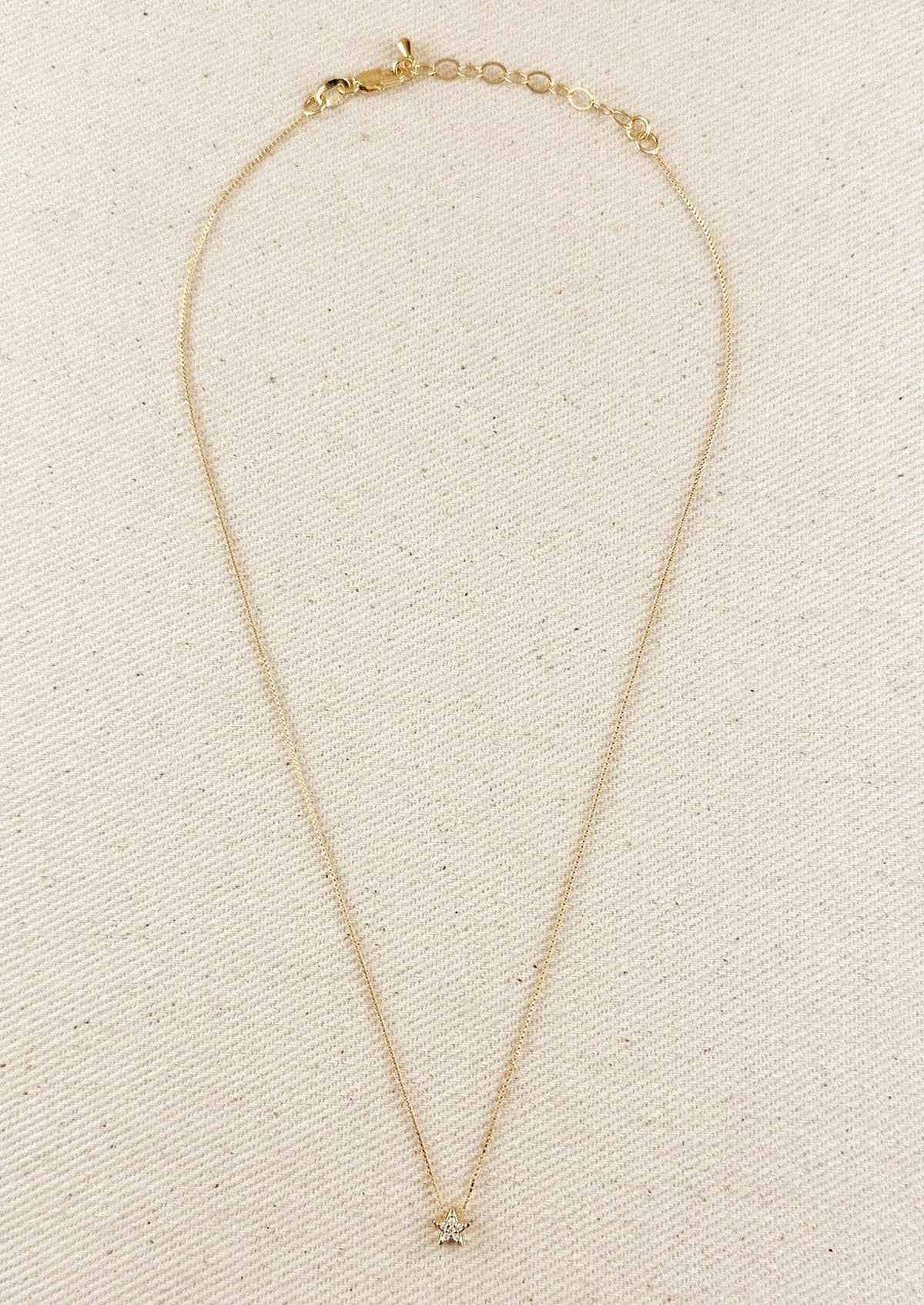 A gold box chain necklace with small gold & crystal star charm.