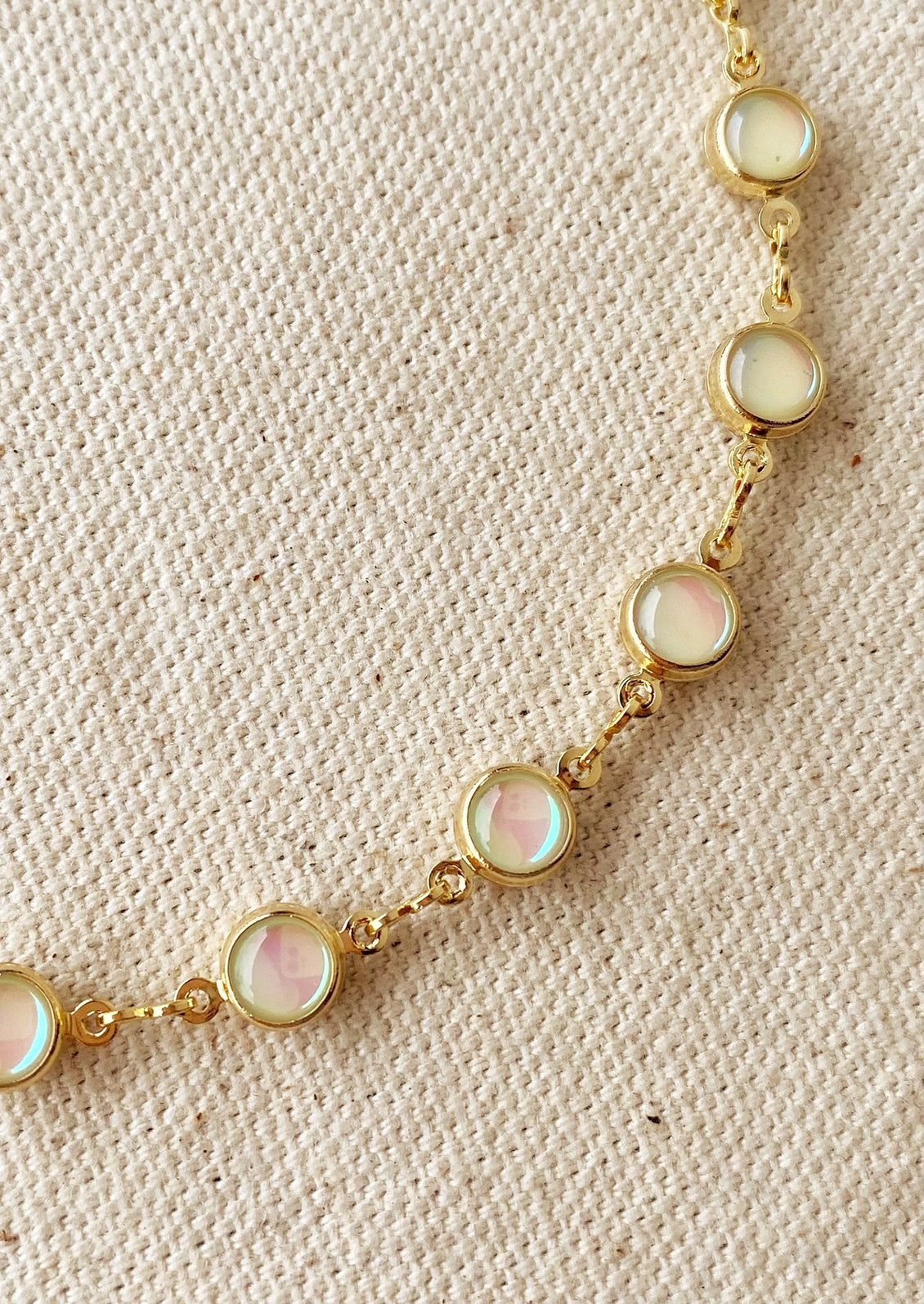 A gold necklace with round opal stations throughout.