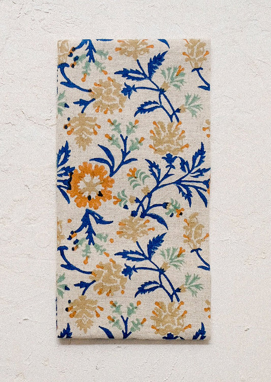 A linen napkin with blue and orange color floral print.