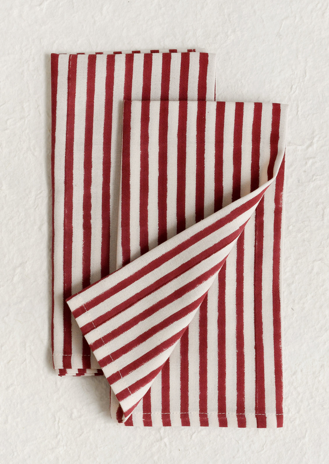 A pair of cotton napkins in vertical red and cream stripe.