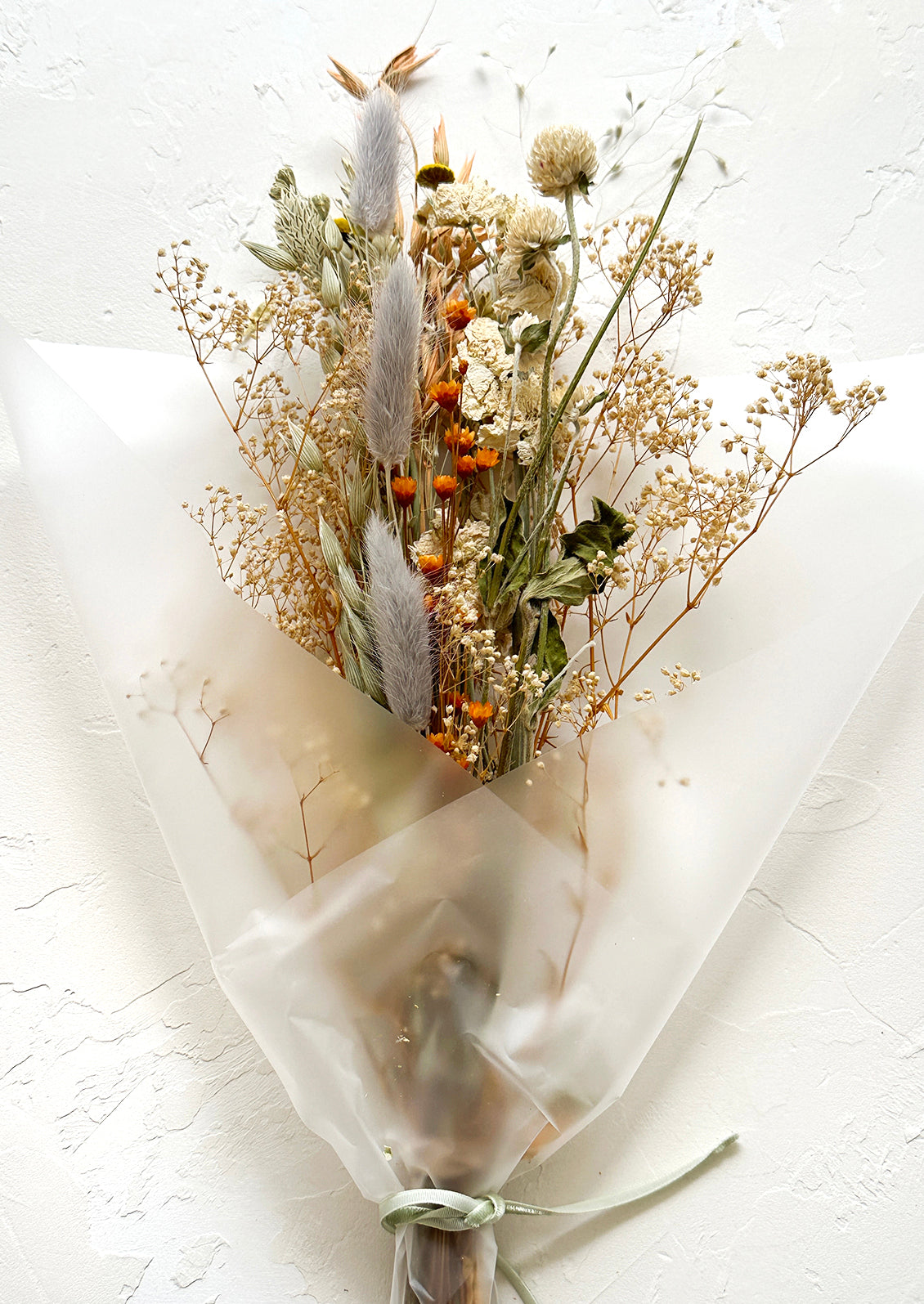 A multicolor bouquet of dried flowers in dusty color palette.