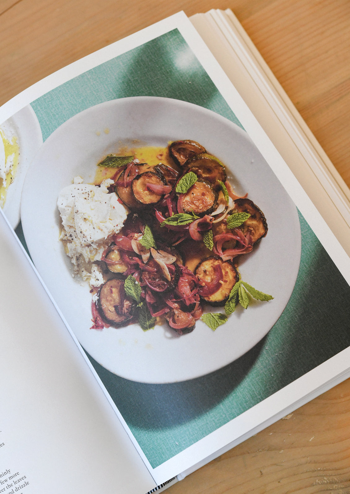 An open cookbook showing a dish with eggplants.