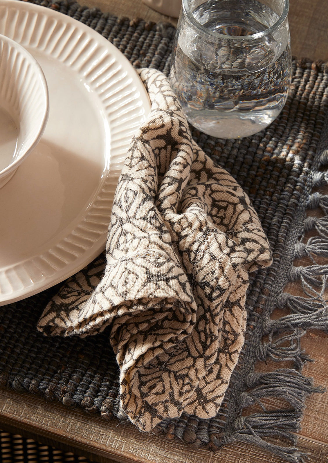 A napkin in patterned grey and cream cotton gauze.