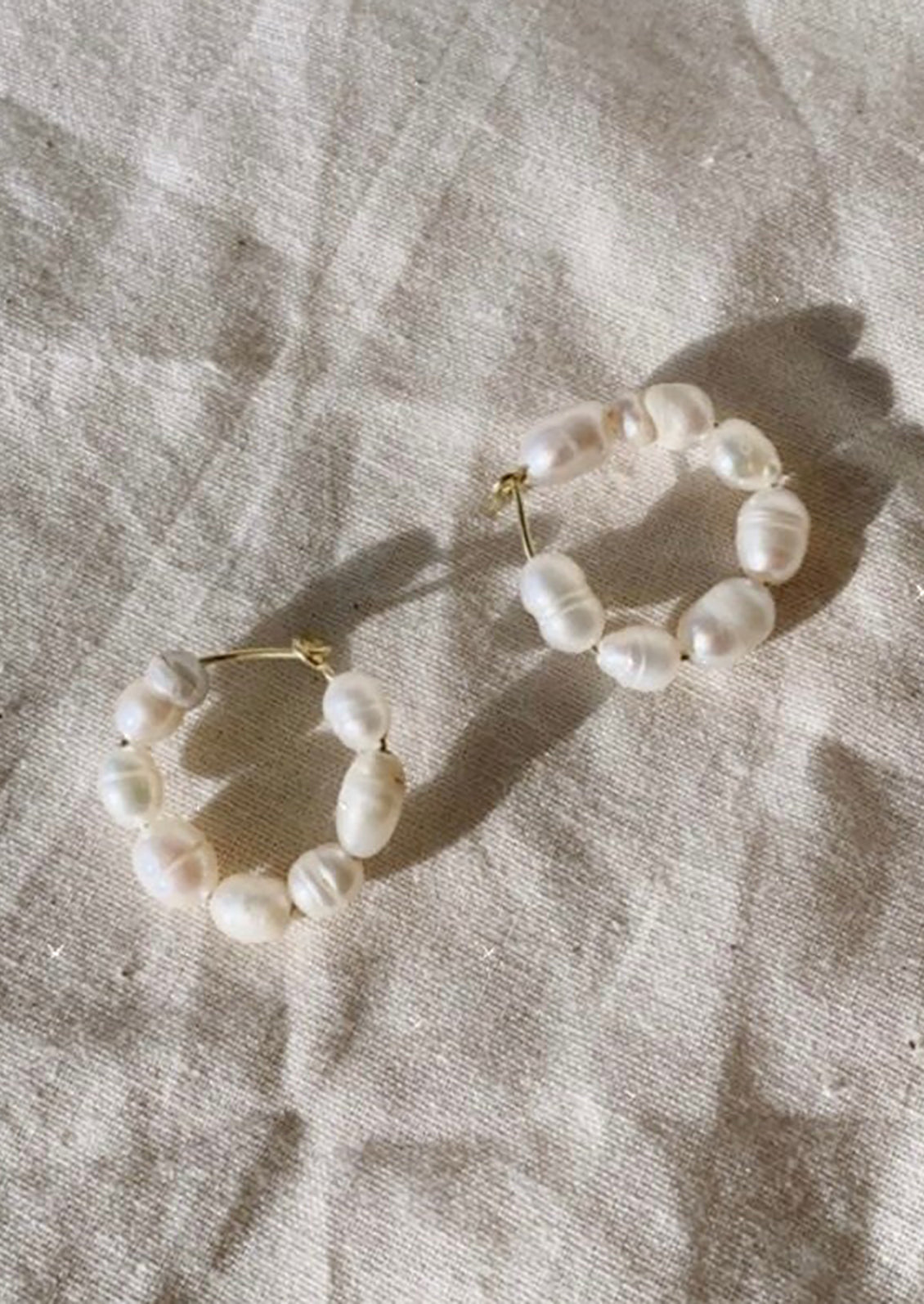 A pair of beaded baroque hoop earrings.