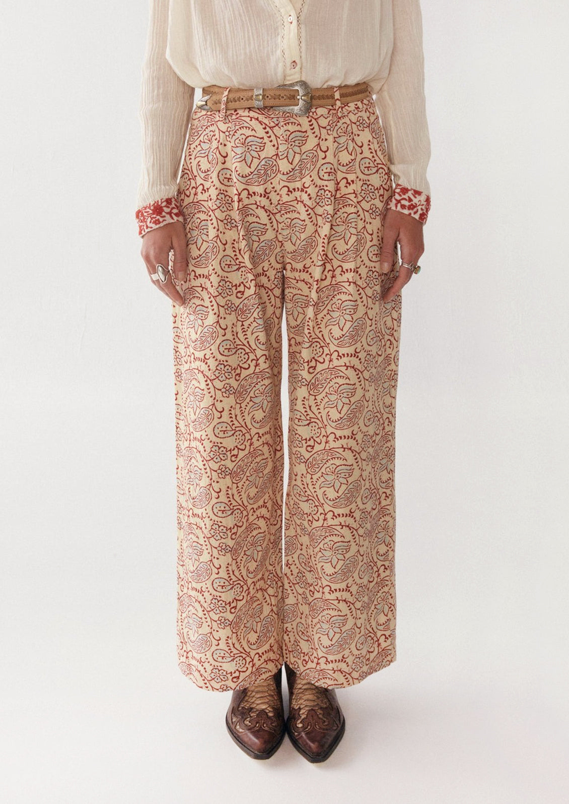 Woman wearing cream, red, and blue paisley printed pants. 