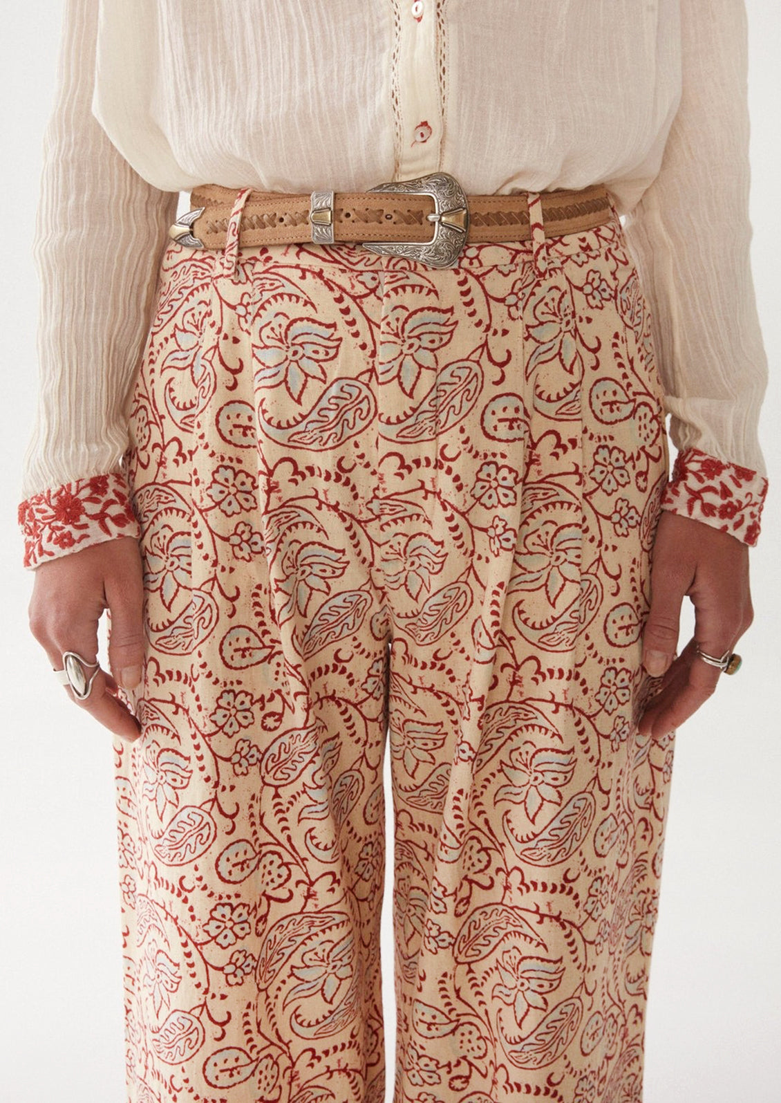Woman wearing cream, red, and blue paisley printed pants.