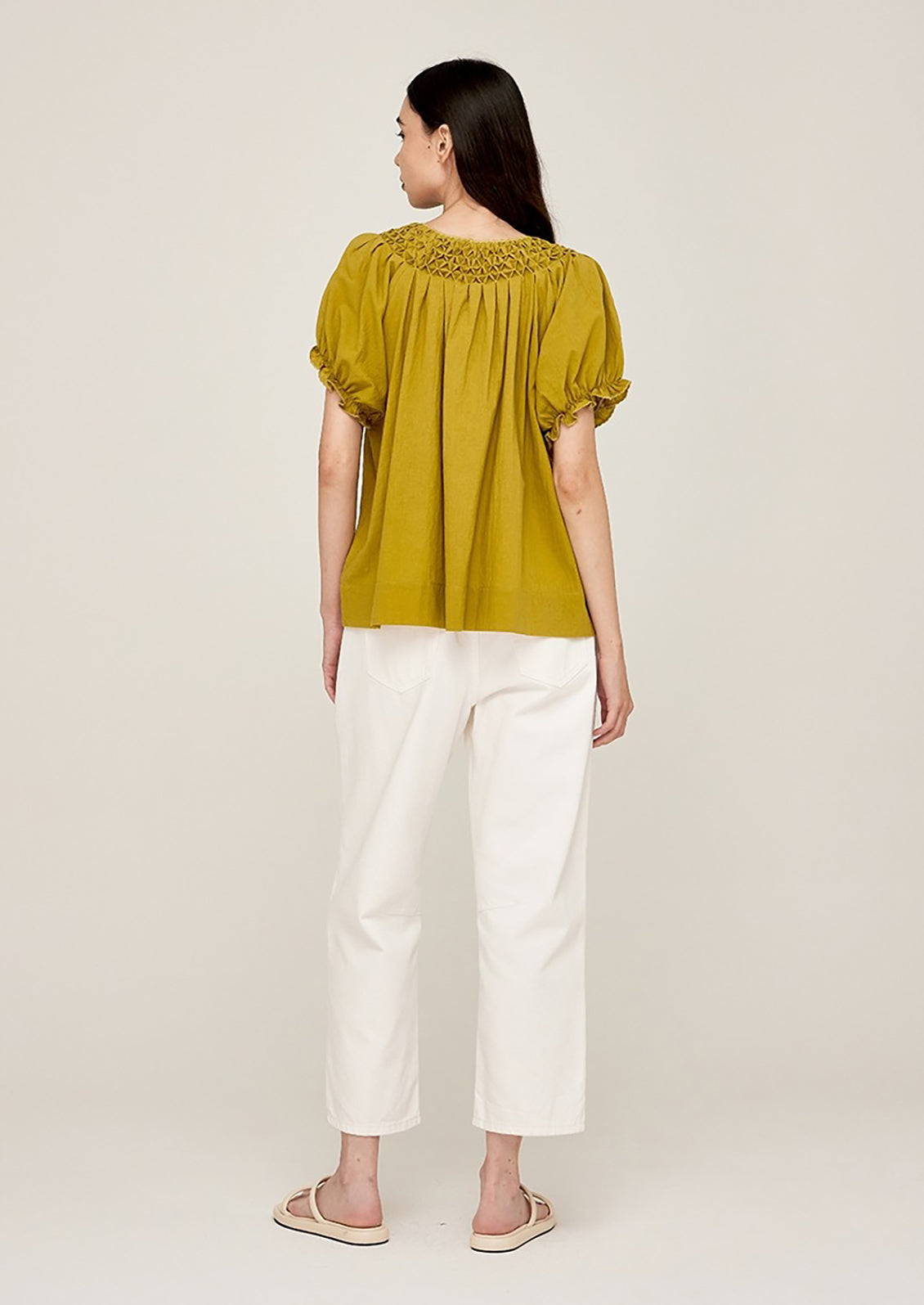 A woman wearing a lime green blouse with short sleeves.
