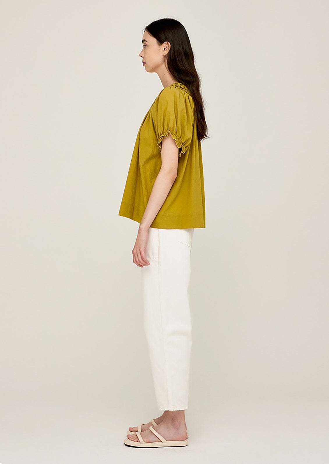 A woman wearing a lime green blouse with short sleeves.