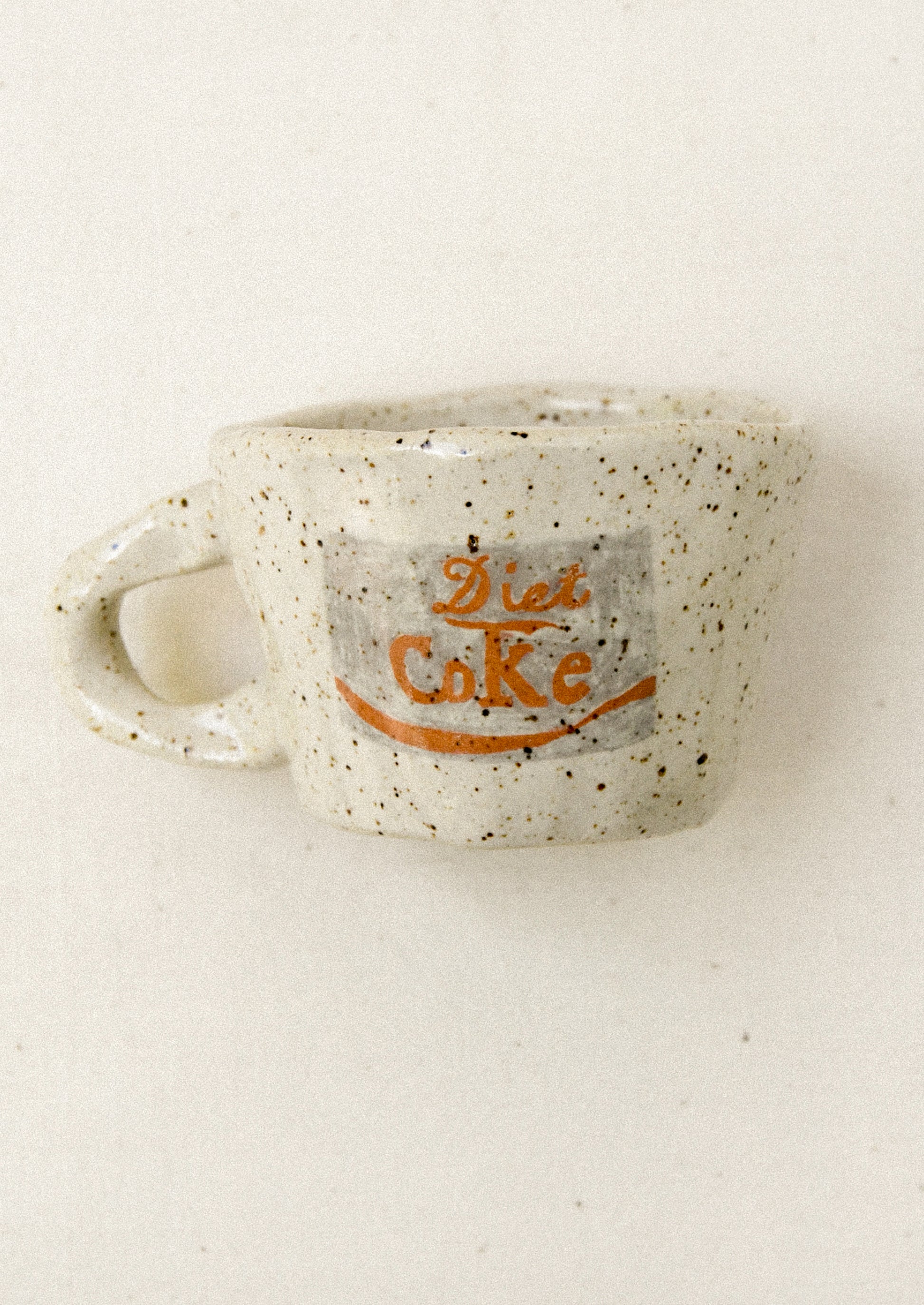 Speckled ceramic mug with 'Diet Cake' text on a white background