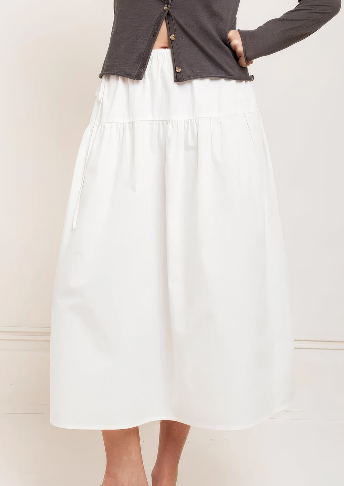 A person wearing a white midi skirt.
