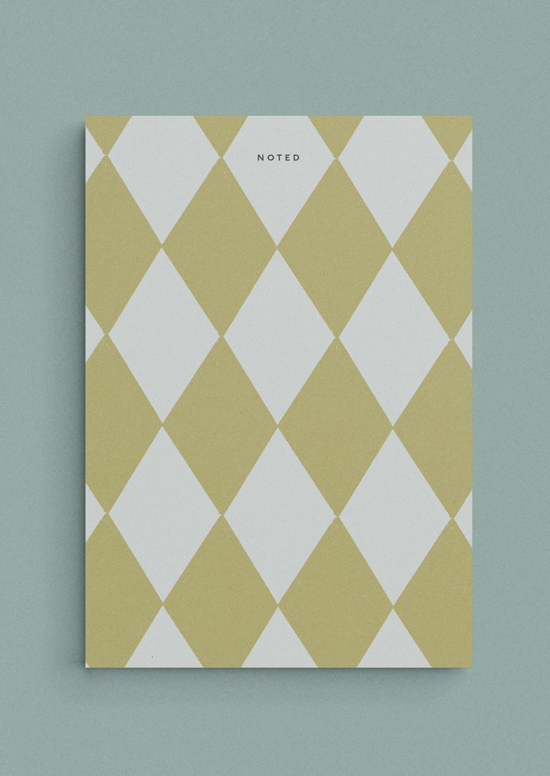 A diamond print notepad in green and light blue reading "NOTED" at the top.
