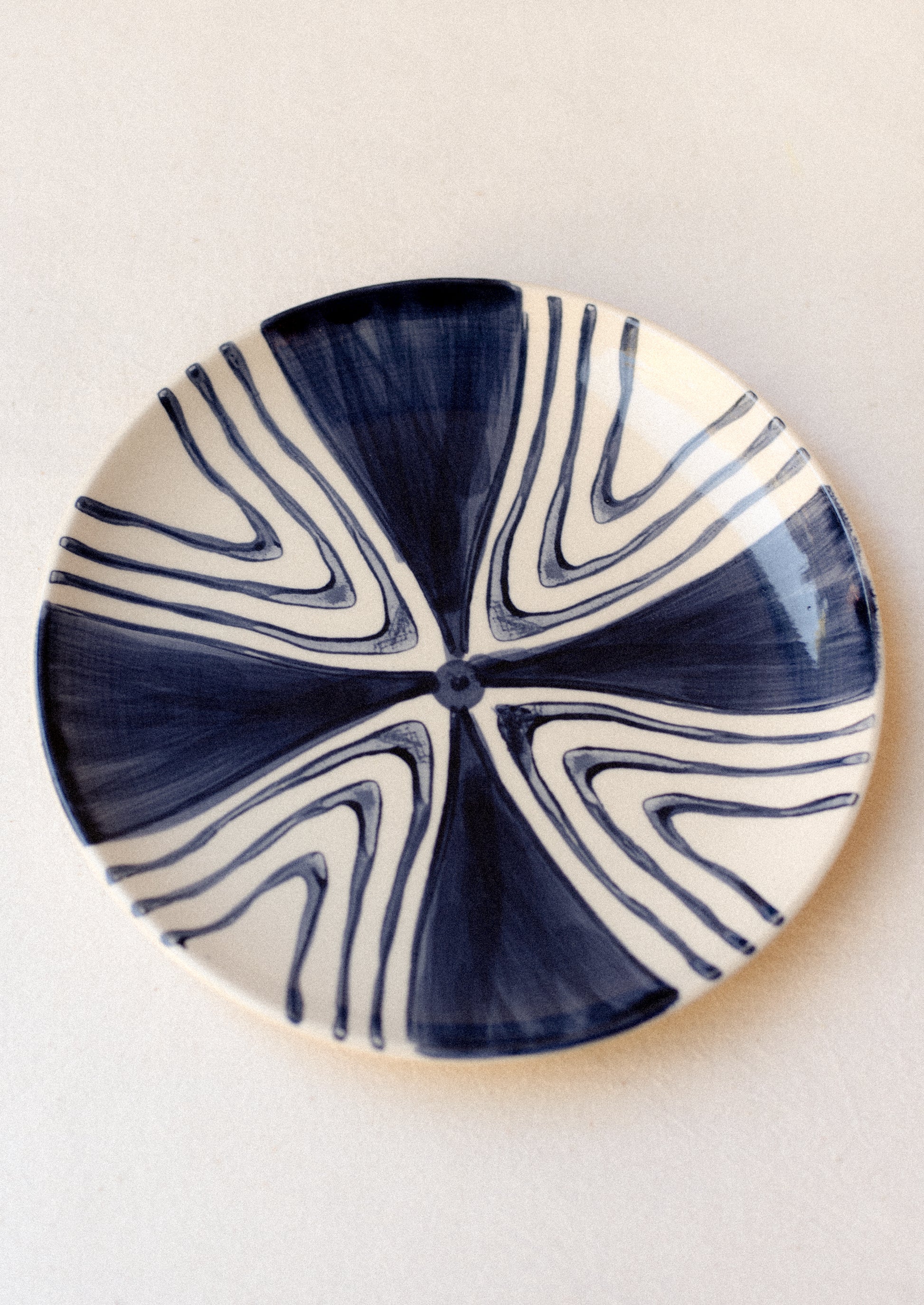 A plate with hand painted triangle peak design in navy blue.