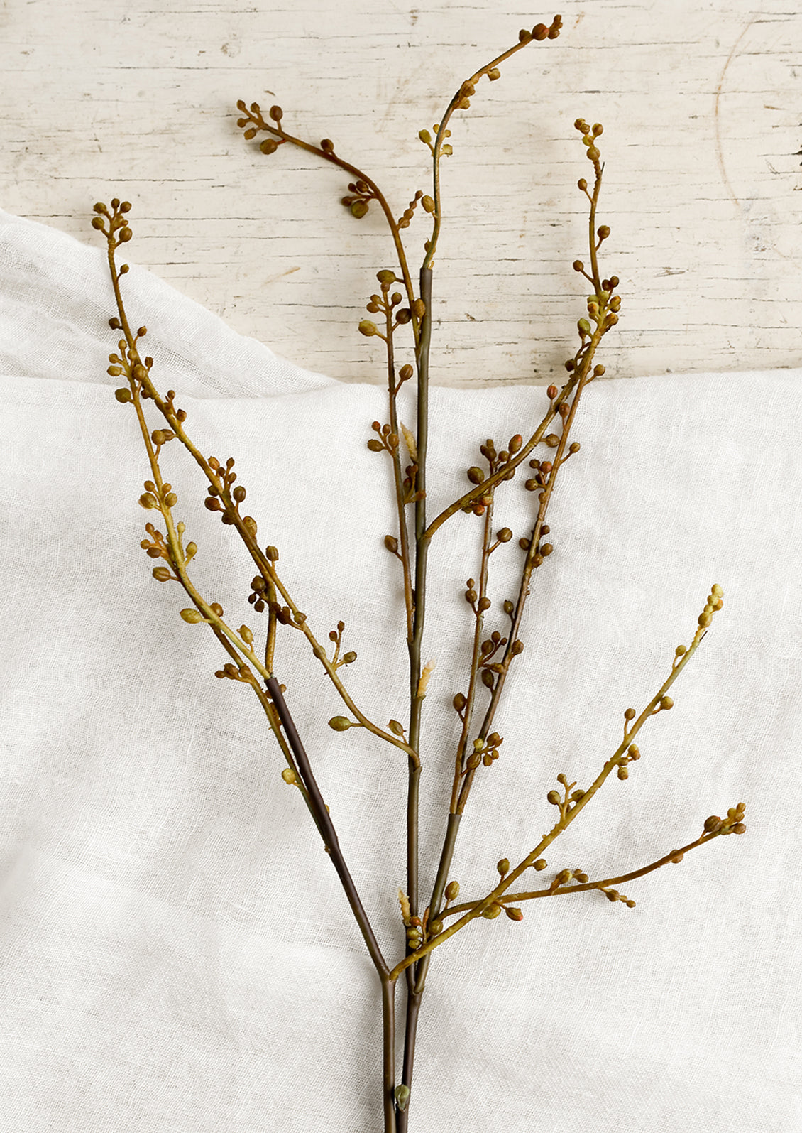 A decorative faux spray looking like a seeded branch.