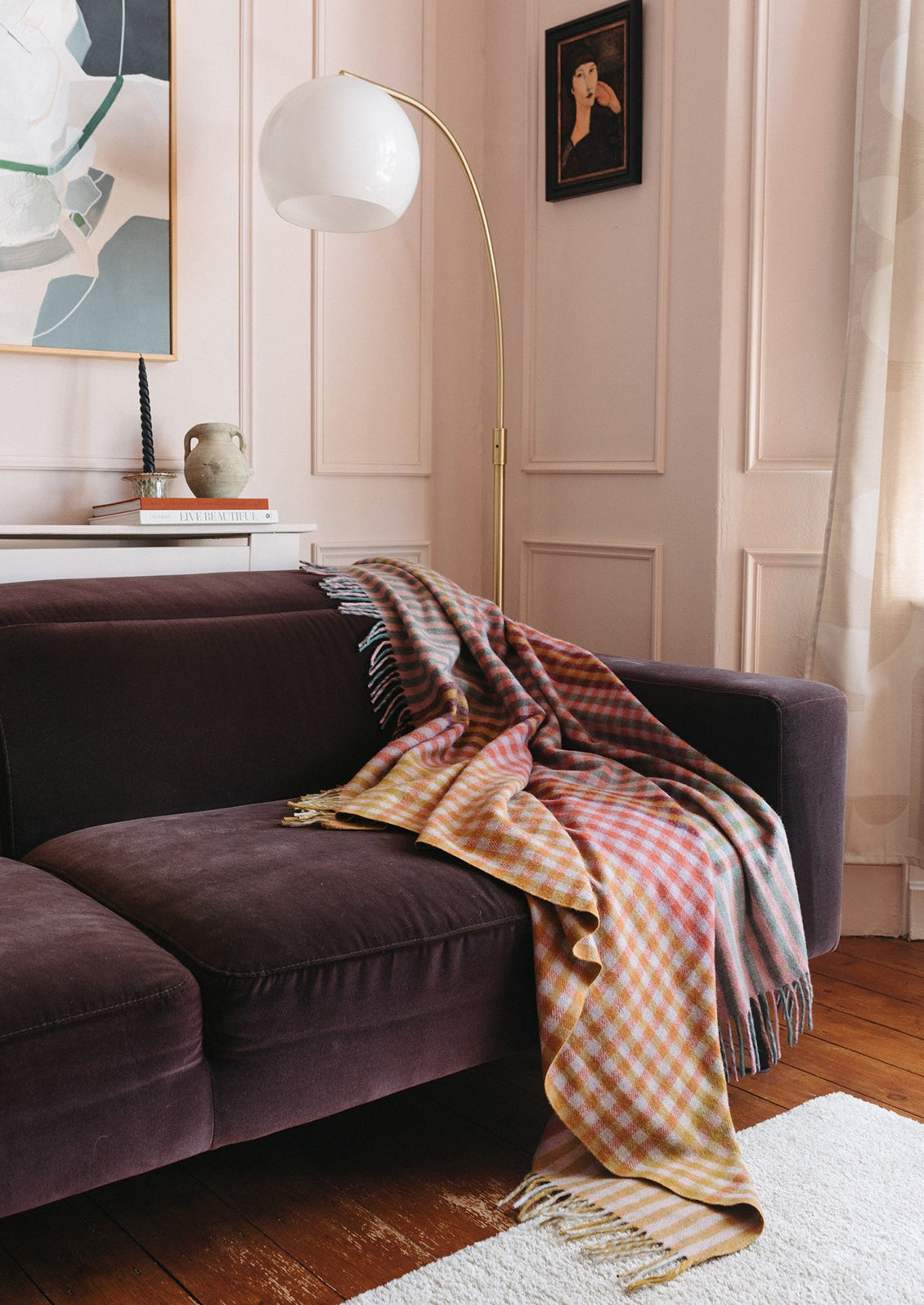 A colorful gingham check blanket in tones of lilac, magenta, and yellow.