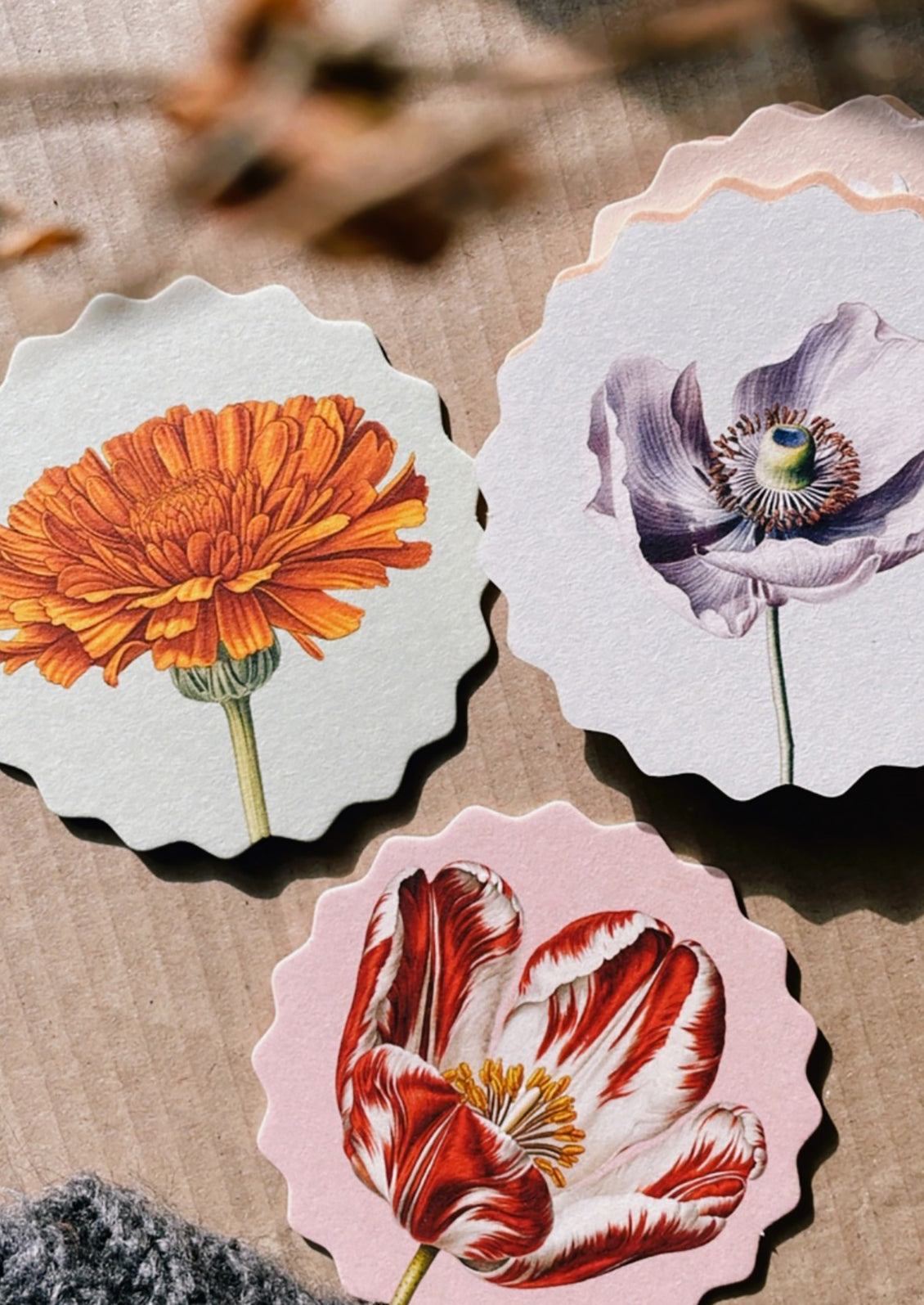 A set of scalloped edge paper coasters with 10 different flower prints.