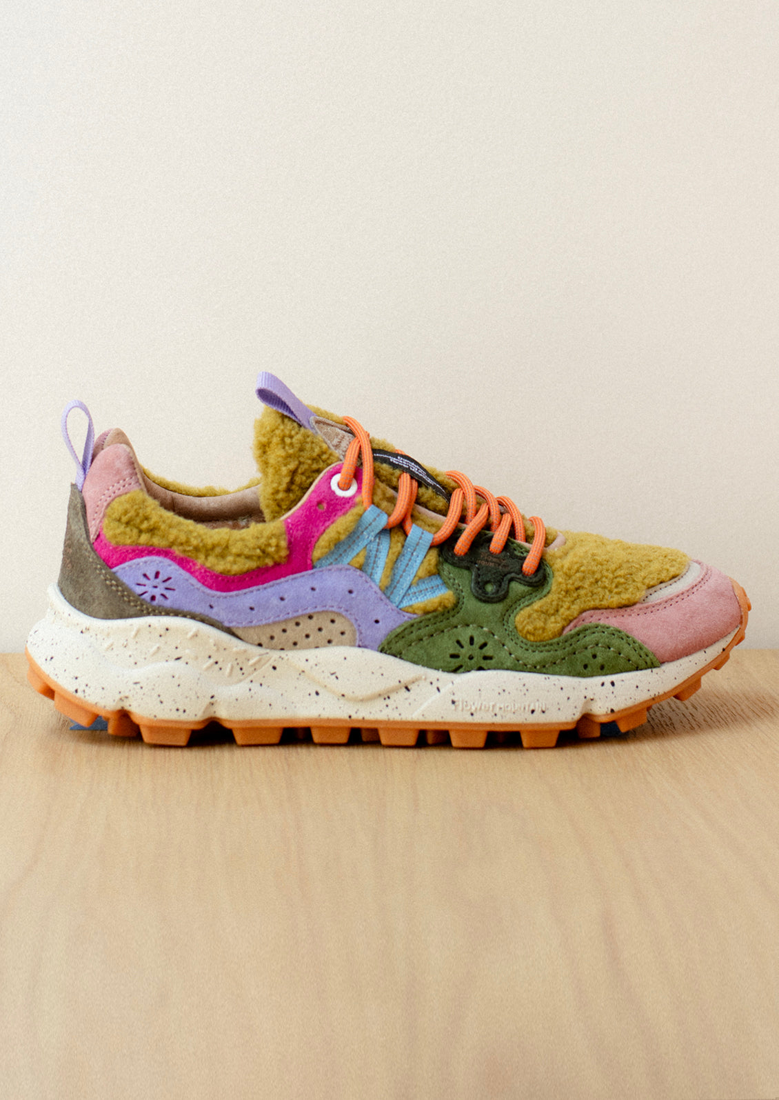 A pair of sporty sneakers in bright multicolor with ochre shearling upper.