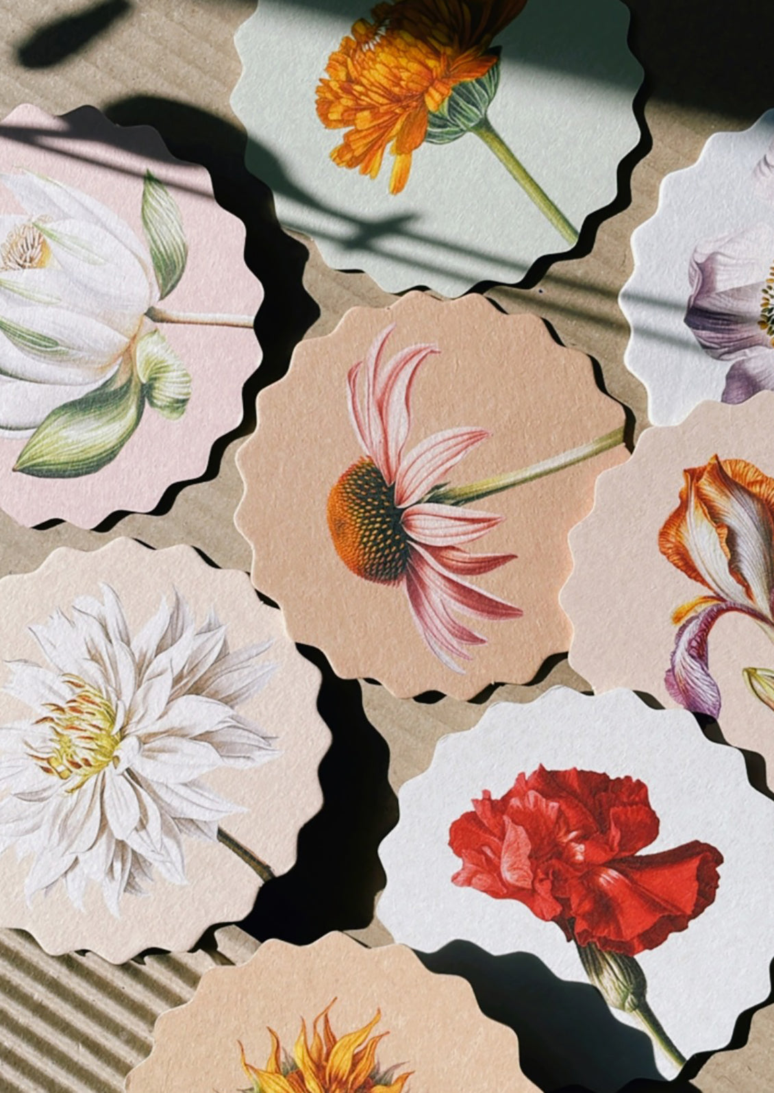 A set of scalloped edge paper coasters with 10 different flower prints.