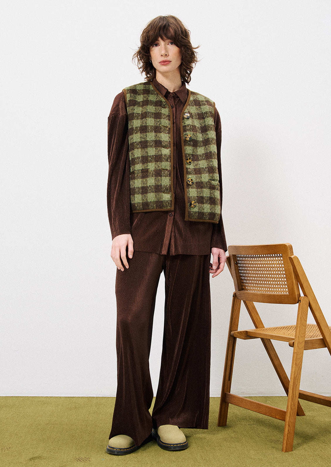 A woman wearing a pair of brown mini pleat pants.