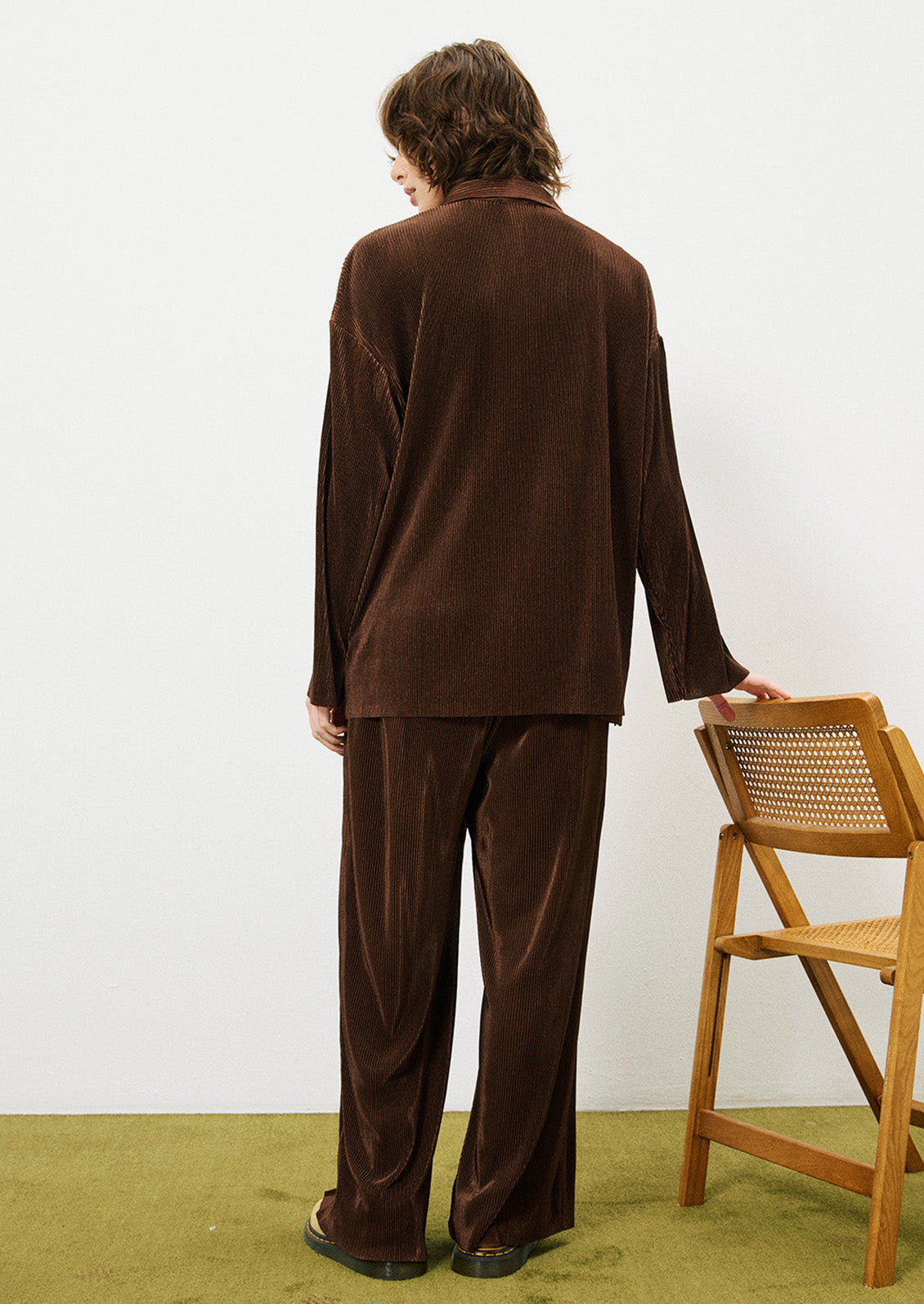 A woman wearing a pair of brown mini pleat pants.
