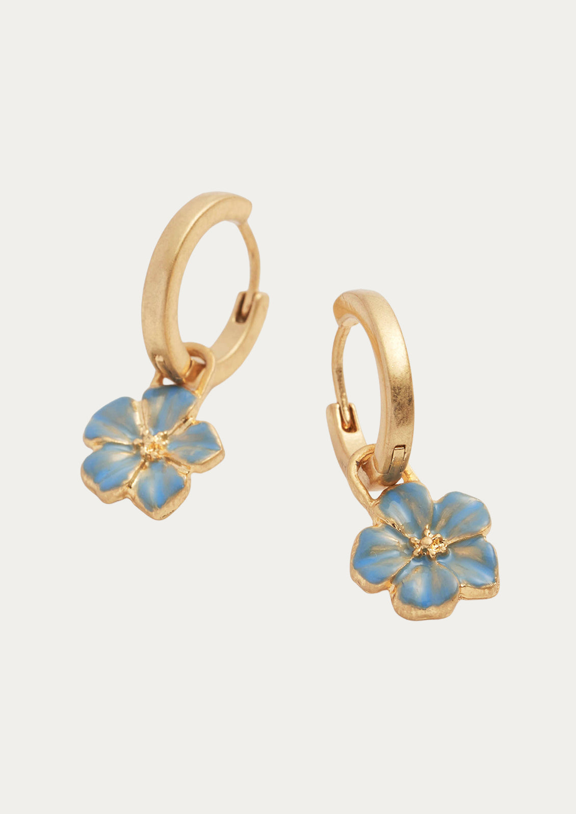 A pair of gold hoops with blue forget me not flower charms.