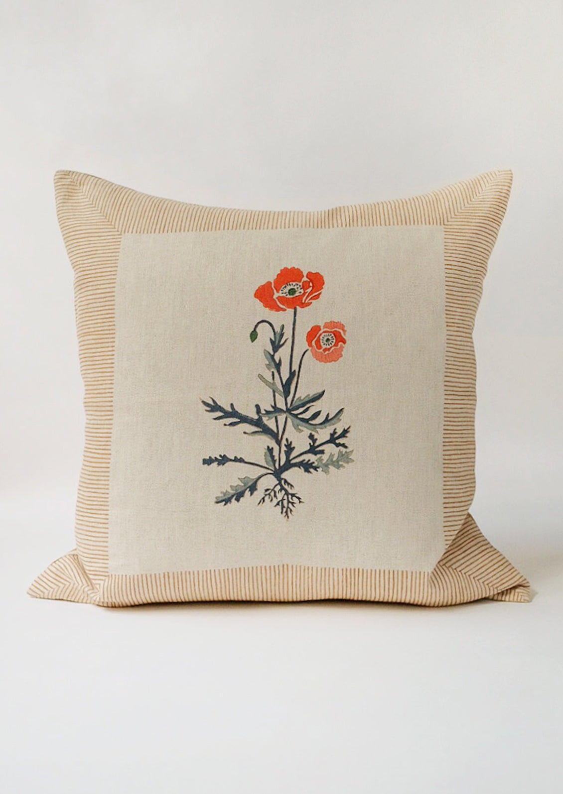 A square block printed throw pillow with framed poppy design.