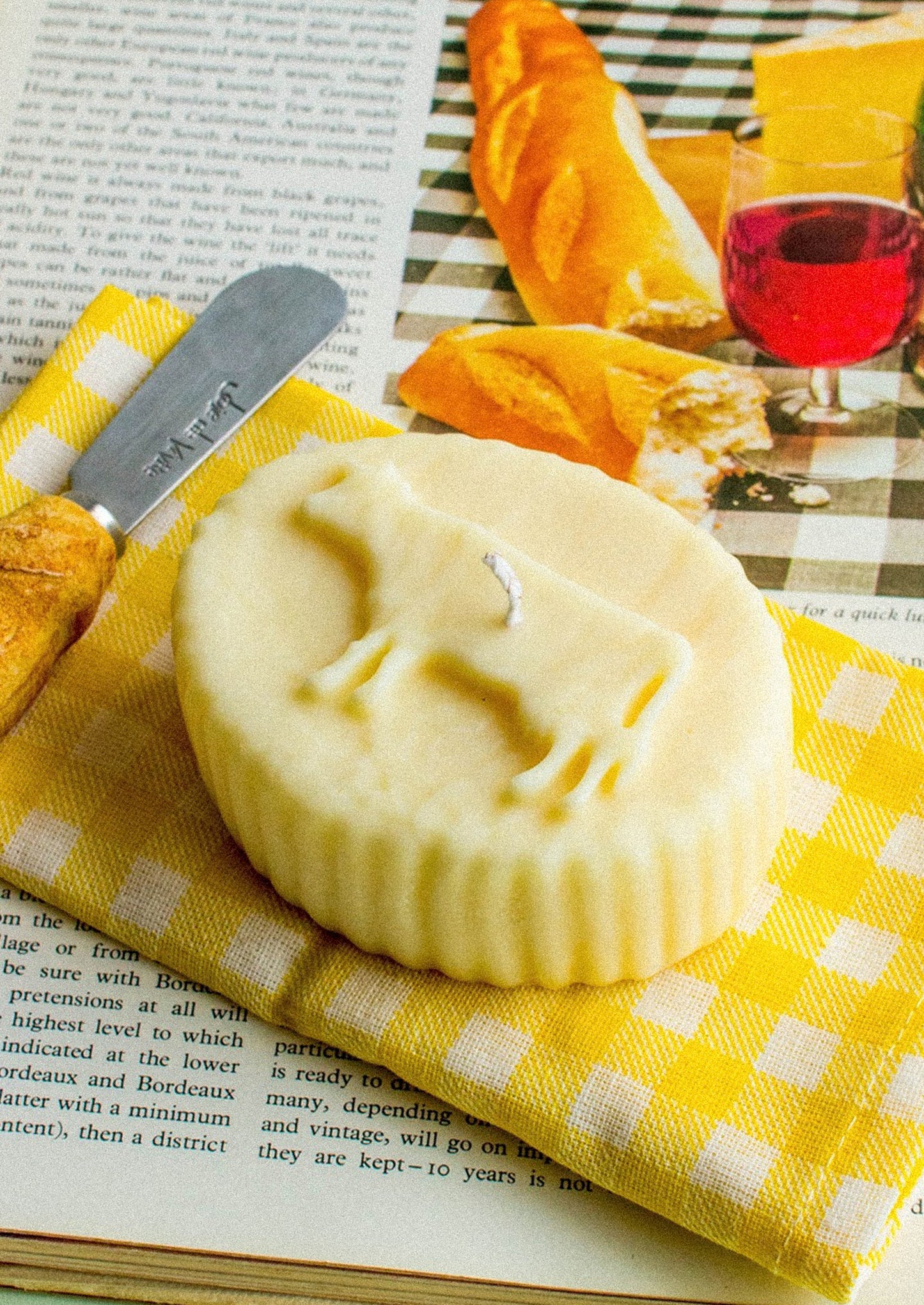 A realistic looking candle in the shape of french butter with cow shape.