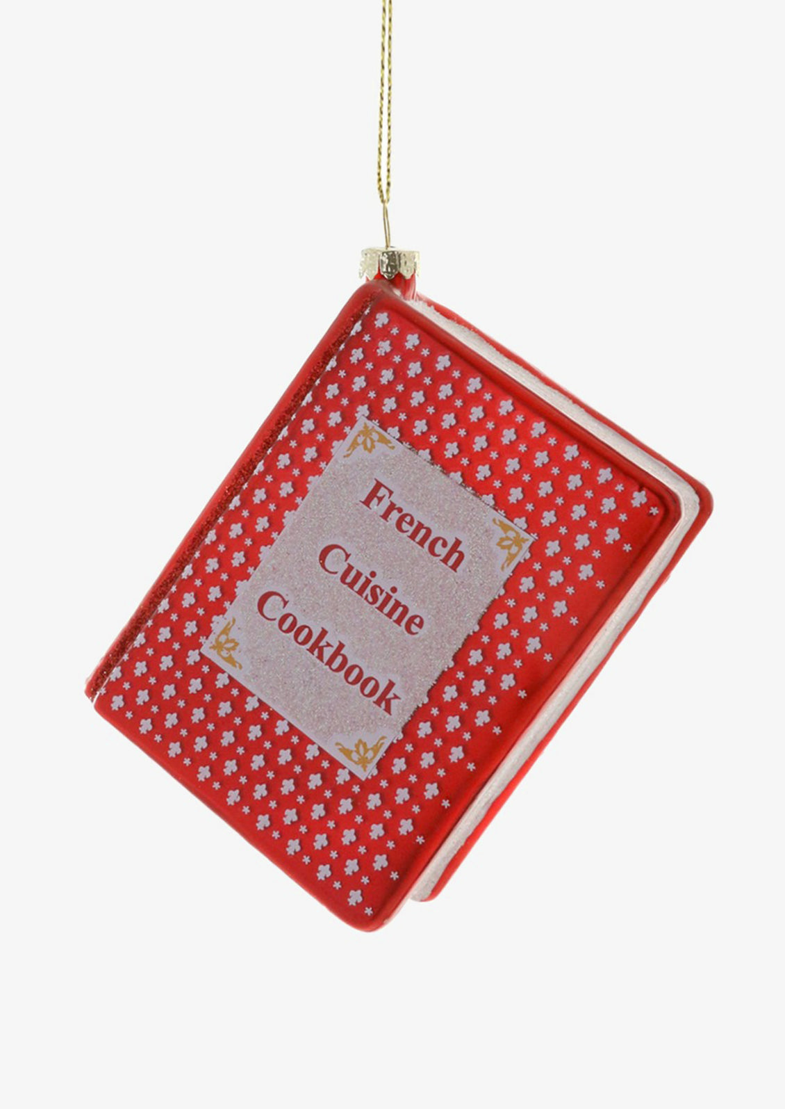 A glass ornament of a red cookbook reading "French Cuisine Cookbook" on cover.