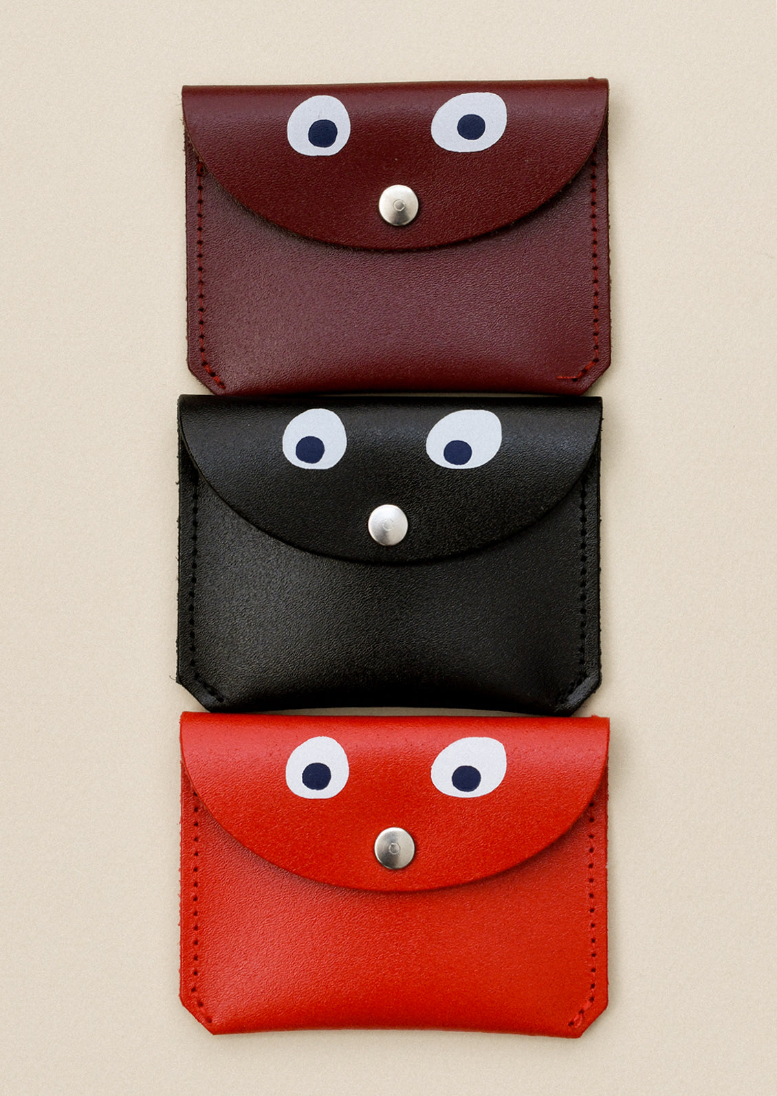 Leather coin pouches in assorted colors with hand painted googly eye detail.