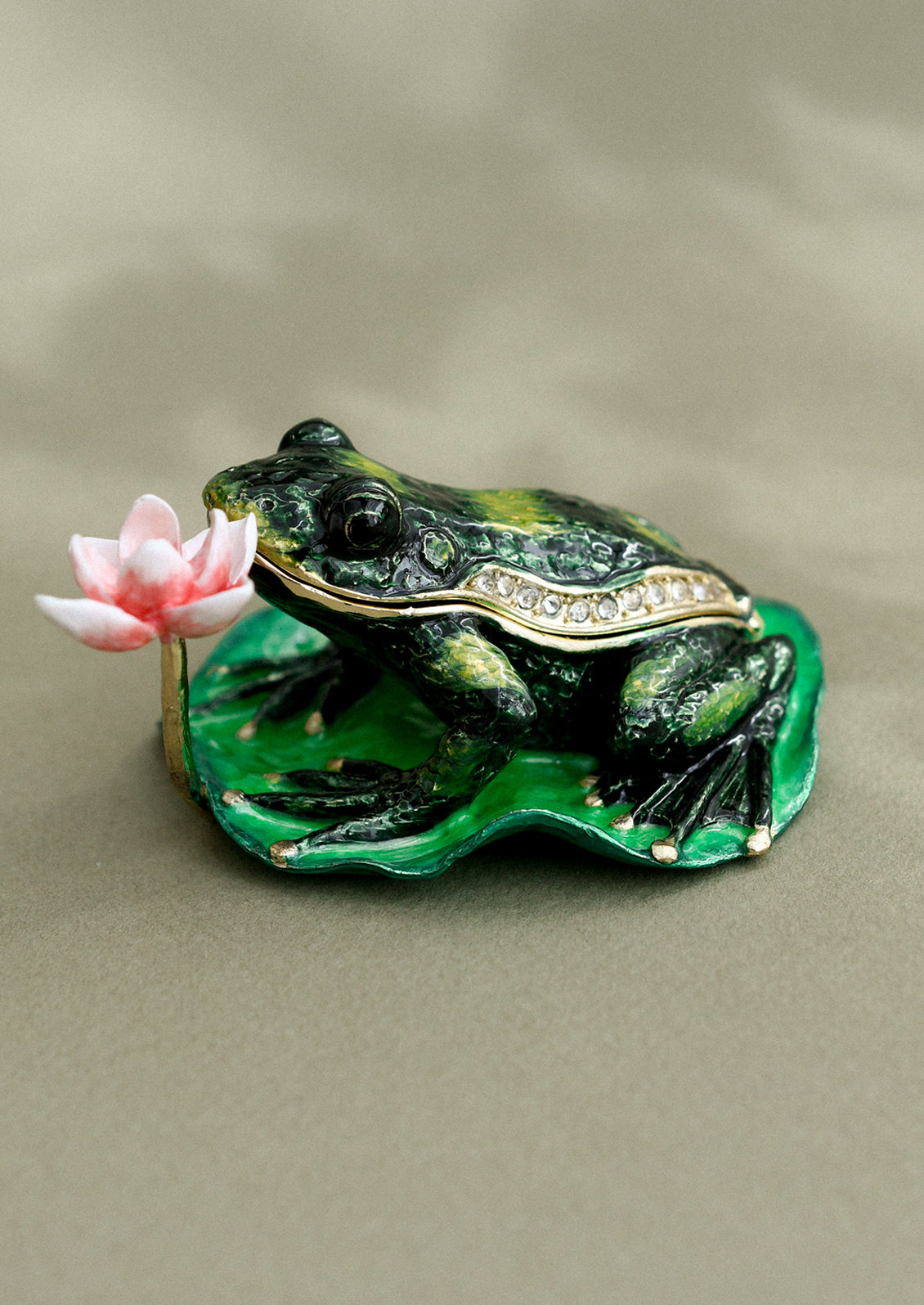 A crystal detailed metal trinket box depicting a frog on lilypad with pink lily.