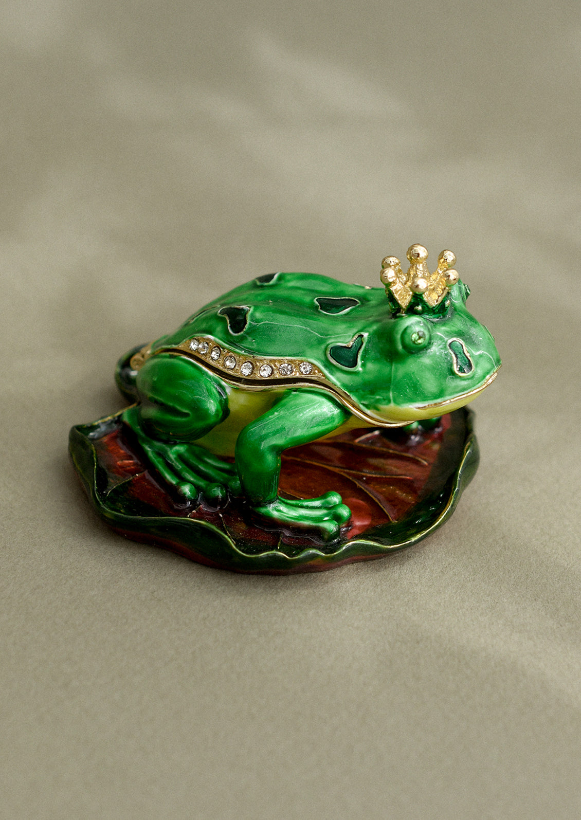 A crystal detailed metal trinket box depicting a frog with gold crown.