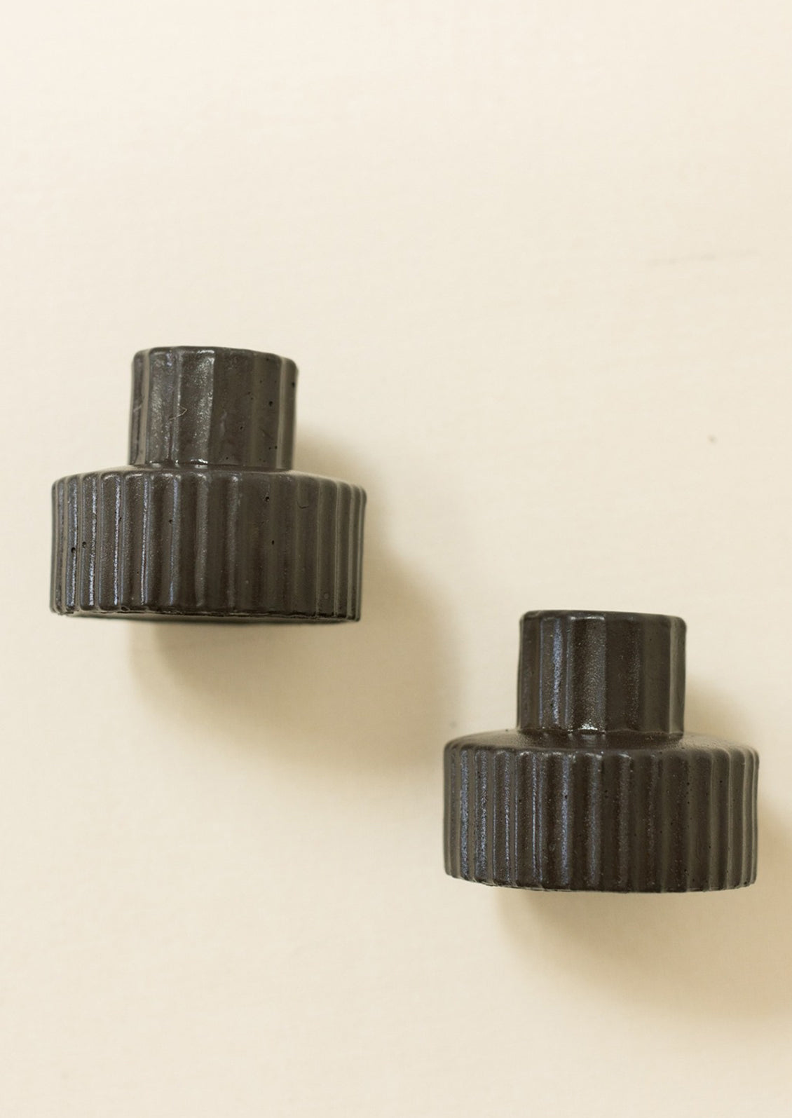 Black fluted taper candle holders in short/wide shape.