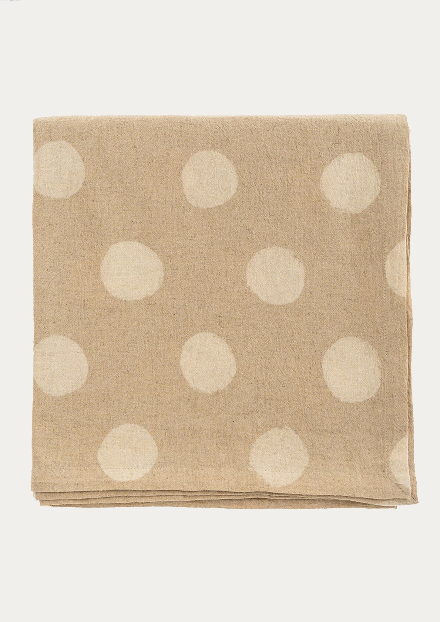 A  beige tablecloth with polka dot resist pattern throughout.