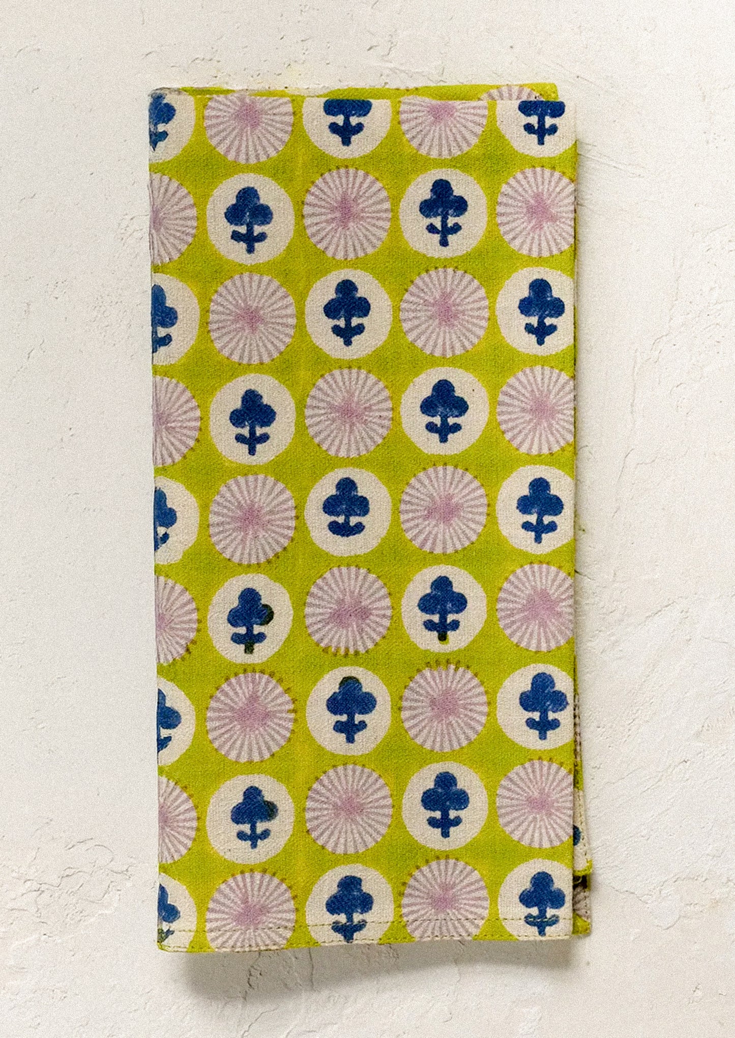 Lime green dinner napkin with floral pattern on a white background